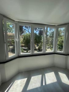 una habitación vacía con 4 ventanas en un edificio en Apartamento em Cascais, en Cascais