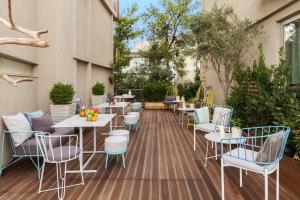a patio area with chairs, tables and umbrellas at Coco-Mat Hotel Nafsika in Athens