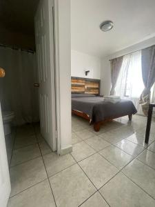 1 dormitorio con cama y ventana en Kunturi Guest House en Arica
