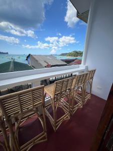 a row of chairs on a balcony overlooking the ocean at Frida Ka in El Nido