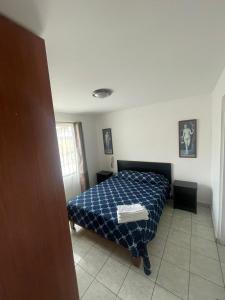 a bedroom with a bed with a blue comforter at Kunturi Guest House in Arica