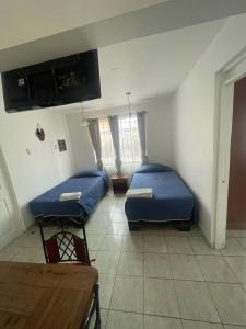 um quarto de hospital com duas camas e uma mesa em Kunturi Guest House em Arica
