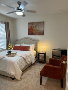 - une chambre avec un lit, un ventilateur de plafond et une chaise dans l'établissement Home SWEET HOME, à Davenport