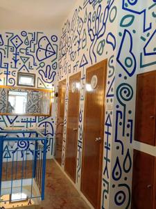 a hallway with a wall covered in blue and white graffiti at Frida Ka in El Nido
