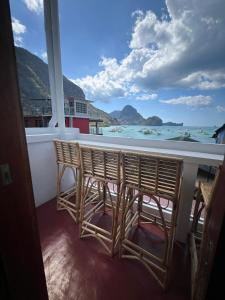Un balcón con dos sillas y vista al mar. en Frida Ka, en El Nido