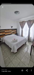 Un dormitorio con una cama con una toalla. en Kunturi Guest House en Arica
