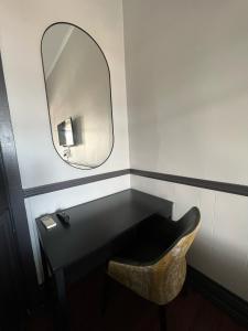 a mirror and a chair in a bathroom at The Federal Hotel in Kalgoorlie