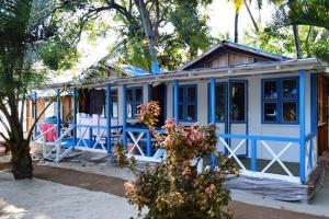 ein blau-weißes Haus mit einem Baum in der Unterkunft Cafe Blue in Palolem