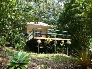 a small house with a balcony in the woods at Vista Hinchinbrook in Cardwell