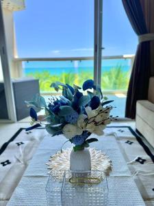 un jarrón lleno de flores azules y blancas en una mesa en Sealink Ocean Vita Condotel Mui Ne 2PN, en Ấp Phú Tịnh (2)