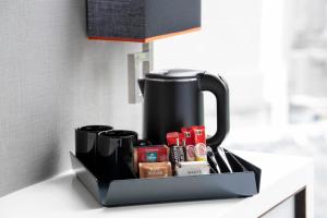 a black coffee pot sitting on a kitchen counter at Quincy Hotel Singapore by Far East Hospitality in Singapore +26 photos
