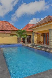 a swimming pool in front of a house at The Salang Guest House in Nusa Penida