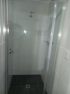 um chuveiro com uma porta de vidro na casa de banho em French Corner Apartments em Dubbo