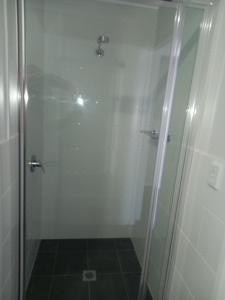 una doccia con una porta in vetro in un bagno di French Corner Apartments a Dubbo