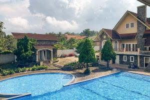 a large swimming pool in front of a house at Urbanview Hotel Villa Q Gisting by RedDoorz in Banjarnegeri