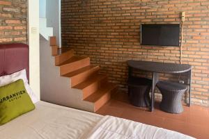- une chambre avec un escalier, une table et une télévision dans l'établissement Urbanview Hotel Villa Q Gisting, à Banjarnegeri