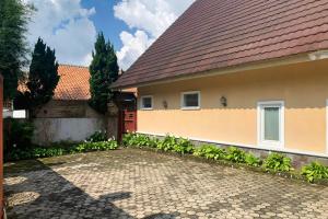 a house with a red door and a brick driveway at Urbanview Hotel Villa Q Gisting by RedDoorz in Banjarnegeri