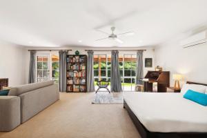 a bedroom with a bed and a couch and a piano at Spacious 4-Bed Hinterland Luxury Escape with Pool in Gold Coast