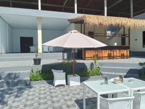 un patio con ombrellone, tavoli e sedie di Scuba Tribe Bali dive-resort a Tulamben