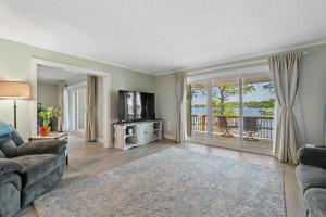 a living room with a couch and a television at Water Front Condo with Boat Slip: The Dock House in Elizabeth City