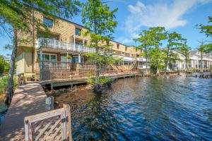 a house with a dock next to a body of water at Water Front Condo with Boat Slip: The Dock House in Elizabeth City