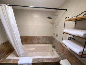 een badkamer met een bad, een douche en handdoeken bij Casa las Trojes in Aguascalientes