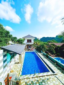 an image of a swimming pool in front of a house at The Hillside Homes in Phong Nha