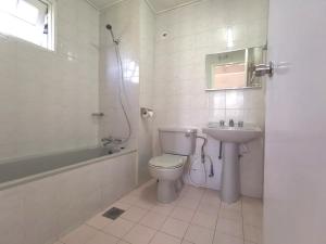 a white bathroom with a toilet and a sink at Green Hill Apartment, Tanah Rata, CameroN in Tanah Rata