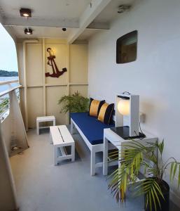 Pokój z niebieską ławką, stołem i telewizorem w obiekcie Doulos Phos The Ship Hotel w mieście Lagoi
