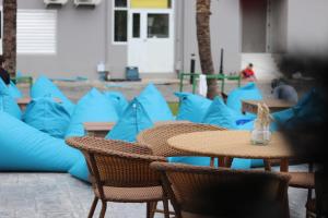 un grupo de mesas y sillas con almohadas azules en Panphuree Residence - SHA Extra Plus en Nai Yang Beach