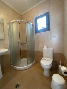 La salle de bains est pourvue d'une douche, de toilettes et d'une fenêtre. dans l'établissement Centrum Rooms, à Kallithéa Halkidikis