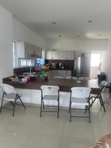 a kitchen with a table and chairs and a counter at Residencia en Oaxtepec in Oaxtepec
