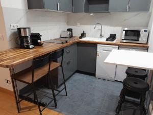 a small kitchen with a wooden counter top and a sink at Studio Marin in Arcueil