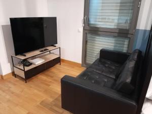 un soggiorno con divano nero e TV a schermo piatto di Studio Marin ad Arcueil