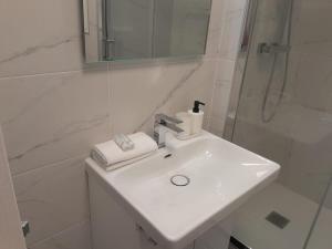 bagno bianco con lavandino e doccia di Studio Marin ad Arcueil