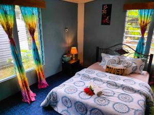 a bedroom with a bed with a comforter and flowers on it at Ravita Cove HomeAway from Home HomeStay in Matacawalevu