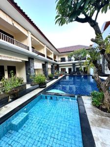a swimming pool in front of a villa at Radha Bali Hotel in Kuta