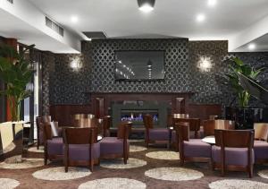 Mid City Motel Warrnambool في وارنامبول: غرفة طعام بها موقد وكراسي وطاولة