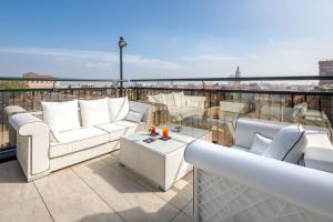 a balcony with couches and a table on a roof at Grande Albergo Roma in Piacenza