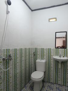 y baño con aseo y lavamanos. en Tetebatu Terrace Homestay, en Tetebatu