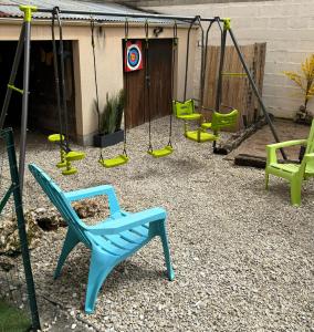une aire de jeux avec des balançoires et une chaise bleue dans l'établissement ESCAPADE en CHAMPAGNE, à Épernay