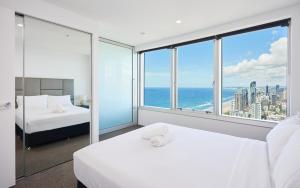 um quarto de hotel com duas camas e uma grande janela em Serain Residences on 9 Hamilton Avenue em Gold Coast