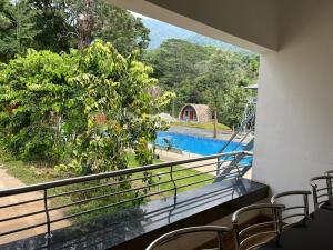 a balcony with a view of a swimming pool at Wild Brooke Hut in Vythiri