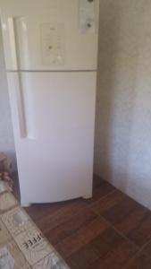 a white refrigerator in the corner of a kitchen at Casa DIMAS in São Pedro