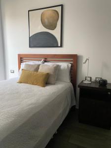 a bedroom with a bed and a table with a lamp at Apartamento moderno 2 habitaciones y 2 banos area Cayala y Embajada USA CASH ONLY in Guatemala