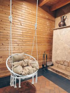 a hanging chair with a pillow in a room at Vila Ambasada in Šventoji