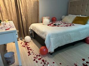 a bedroom with a bed with red balloons on the floor at The Edge of Waterfall in Midrand
