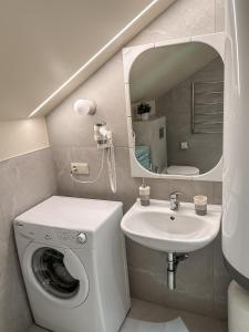 een badkamer met een wasmachine en een wastafel bij Vila Ambasada in Šventoji