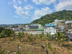 a city with palm trees in front of a mountain at Sunset Mansion in Patong Beach