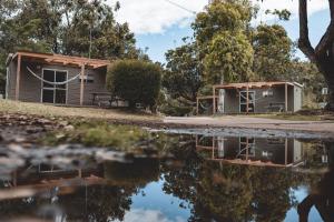a house with its reflection in a pond at Tathra Beach Eco Camp in Tathra